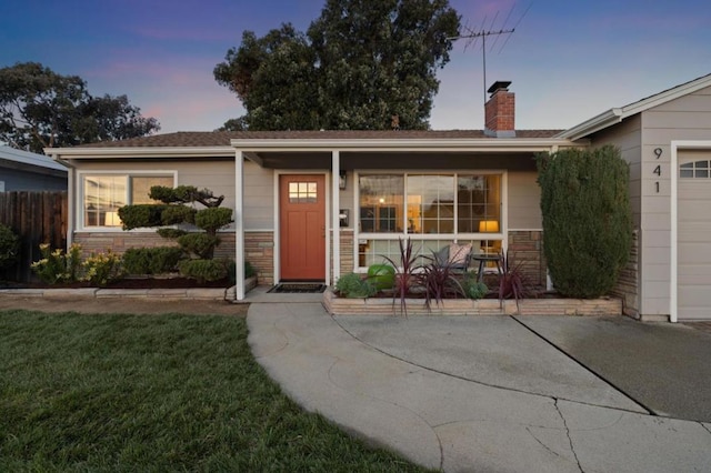 view of front of house with a garage, a lawn, and covered porch