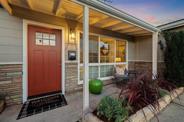 exterior entry at dusk featuring a porch