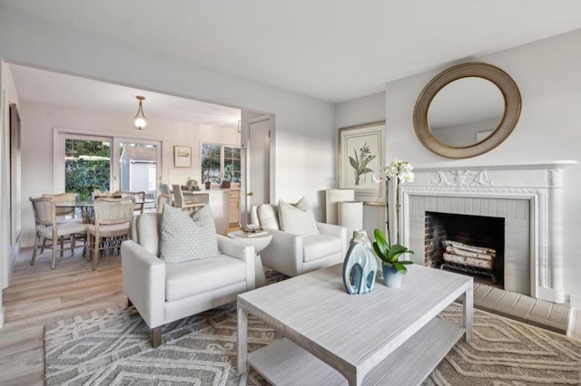 living room featuring a brick fireplace and hardwood / wood-style floors