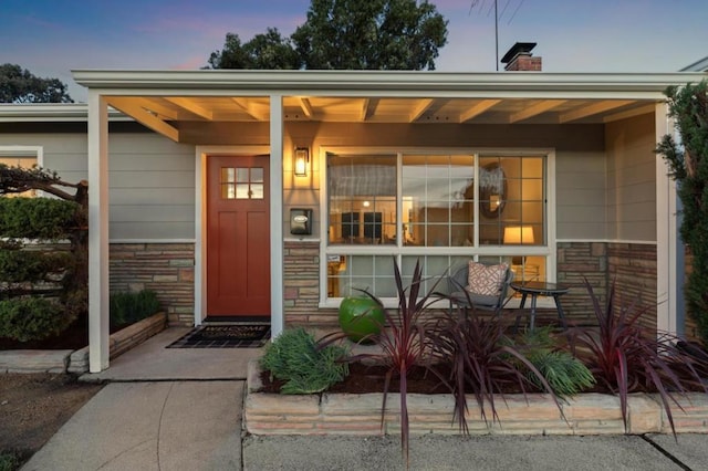 exterior entry at dusk featuring a porch