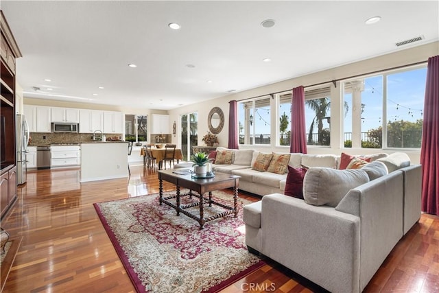 living room featuring hardwood / wood-style flooring and sink