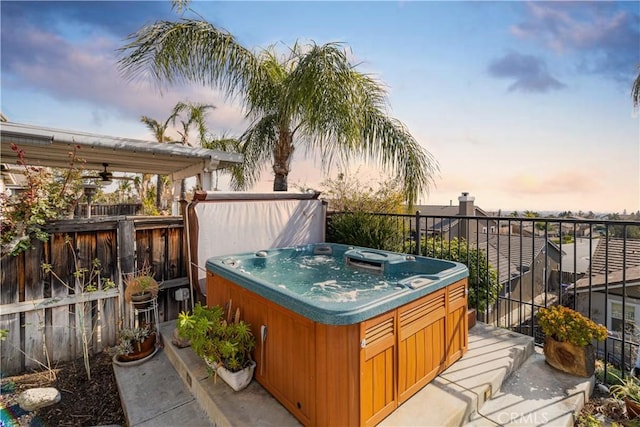 deck at dusk with a hot tub