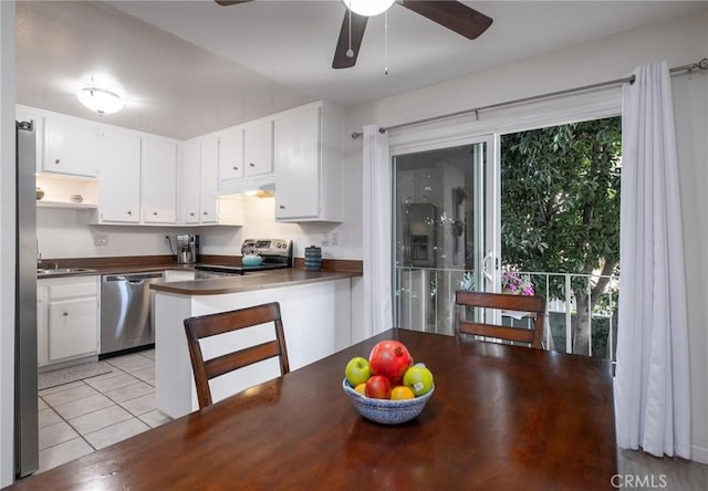 kitchen with sink, white cabinets, light tile patterned floors, ceiling fan, and stainless steel appliances