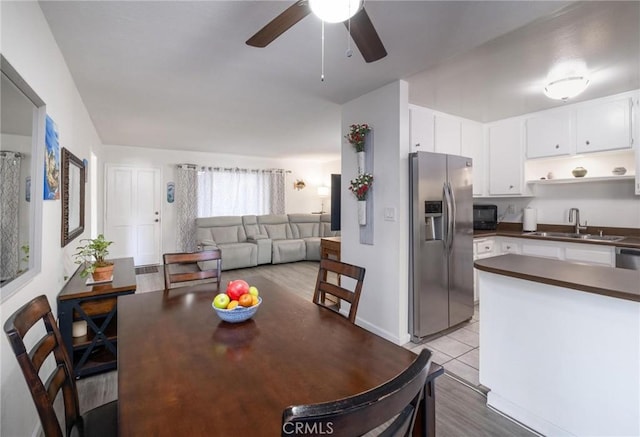 dining area featuring ceiling fan, sink, and light tile patterned floors