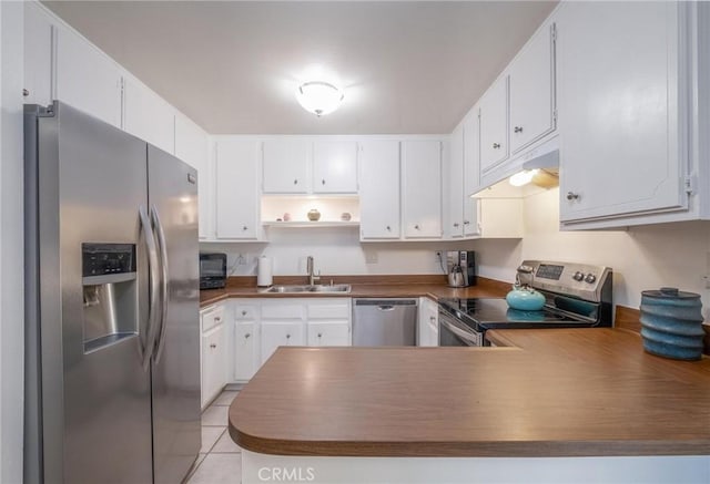 kitchen featuring light tile patterned floors, appliances with stainless steel finishes, sink, and white cabinets