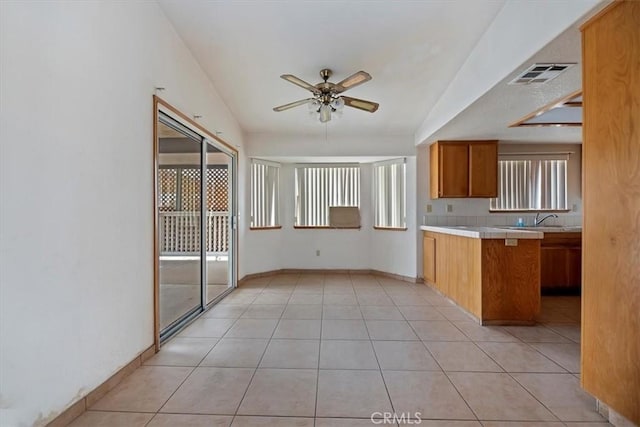 kitchen featuring light tile patterned flooring, plenty of natural light, lofted ceiling, and ceiling fan