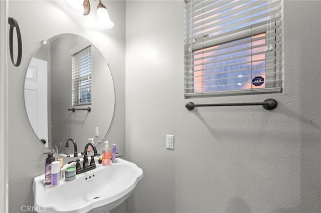 bathroom featuring a sink and a textured wall