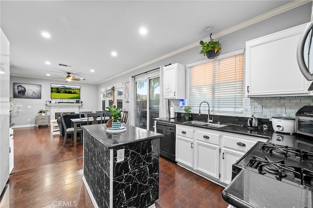 kitchen featuring a fireplace, a kitchen island, a sink, white cabinets, and black appliances