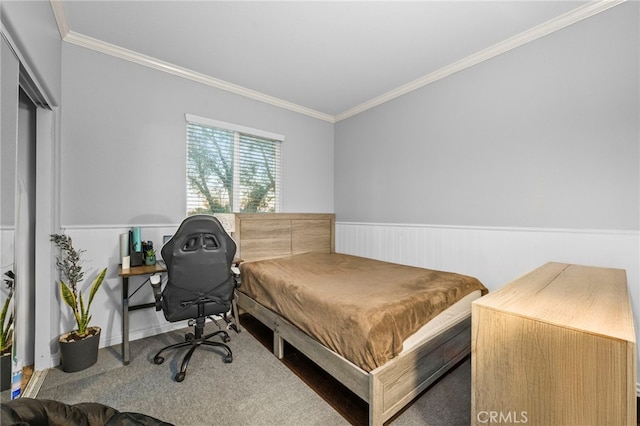 carpeted bedroom with a wainscoted wall and ornamental molding