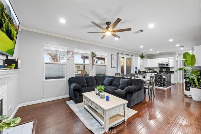 living room featuring ornamental molding, ceiling fan, and dark hardwood / wood-style flooring