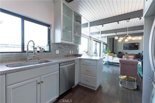 kitchen with sink, white cabinets, decorative backsplash, hanging light fixtures, and stainless steel appliances