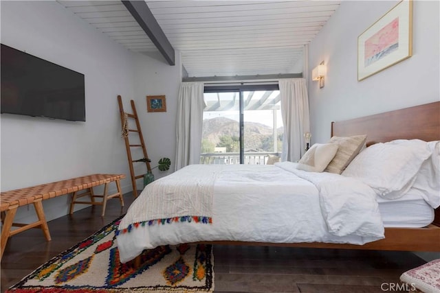 bedroom with dark hardwood / wood-style flooring, a mountain view, access to exterior, and beam ceiling