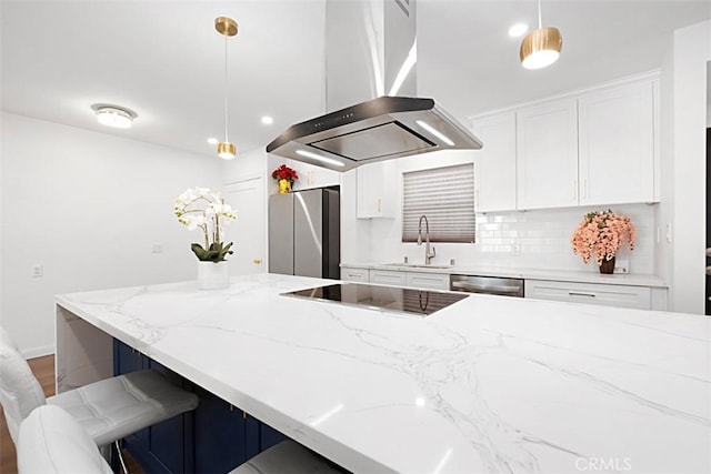 kitchen with sink, island range hood, hanging light fixtures, appliances with stainless steel finishes, and white cabinets