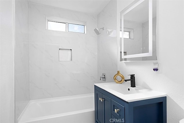 bathroom featuring vanity and tiled shower / bath