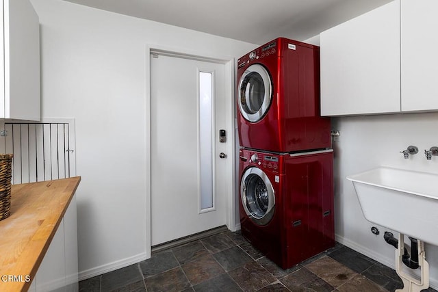 washroom featuring stacked washer and dryer and sink