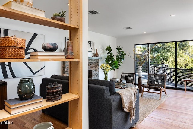 living room with a fireplace and light wood-type flooring