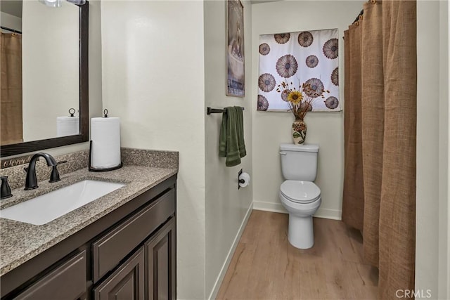 bathroom with vanity, wood-type flooring, and toilet