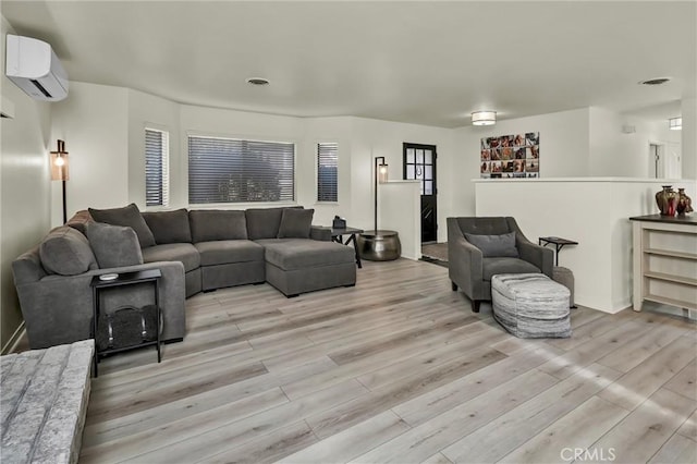 living room featuring a wall mounted AC and light hardwood / wood-style floors