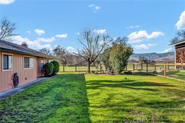 view of yard with a mountain view and a rural view