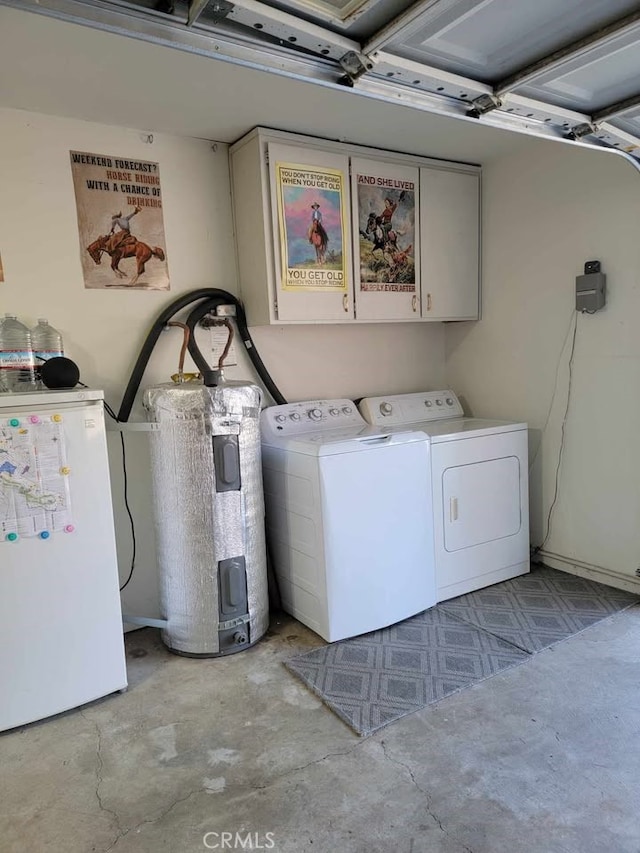 laundry area featuring electric water heater, washing machine and dryer, and cabinets