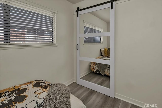 bedroom with hardwood / wood-style flooring and a barn door