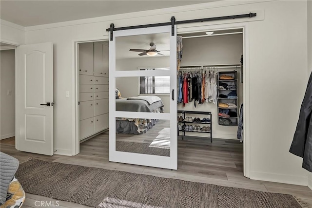 bedroom featuring wood-type flooring and a barn door