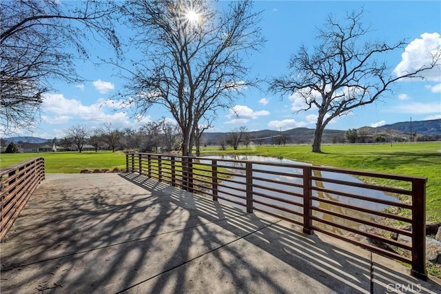 view of property's community featuring a mountain view, a rural view, and a lawn