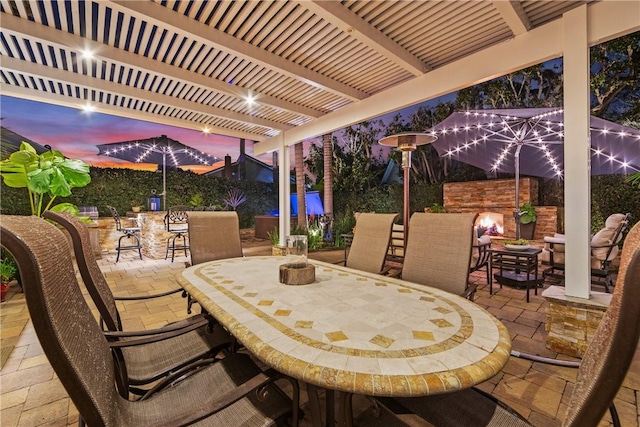 view of patio / terrace with outdoor dining area, a pergola, and a stone fireplace