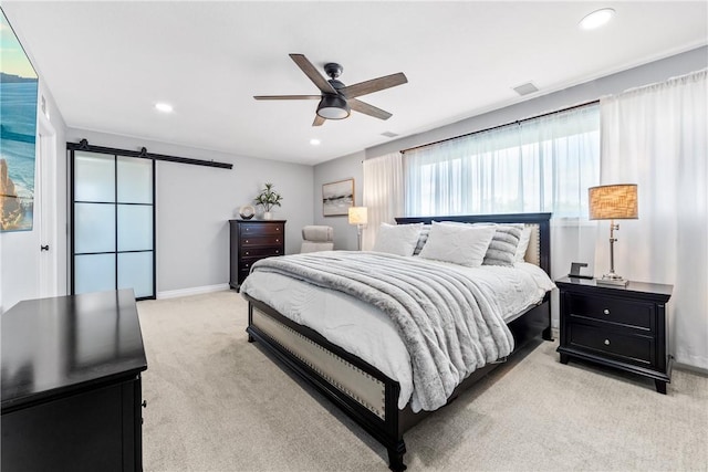 bedroom with a barn door, recessed lighting, light carpet, visible vents, and baseboards