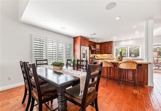 dining room with light wood finished floors, recessed lighting, and baseboards