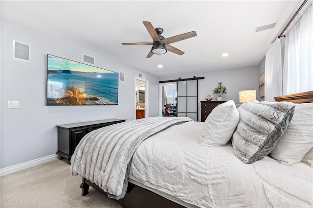 bedroom with light carpet, visible vents, baseboards, and a barn door