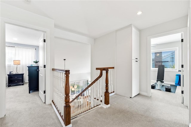 corridor featuring recessed lighting, baseboards, light carpet, and an upstairs landing