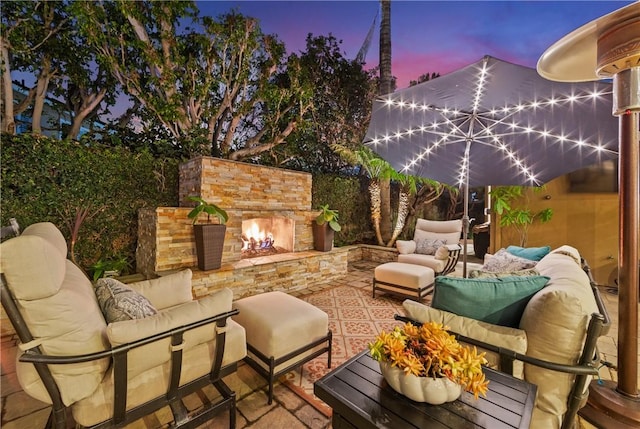 patio terrace at dusk with an outdoor living space with a fireplace