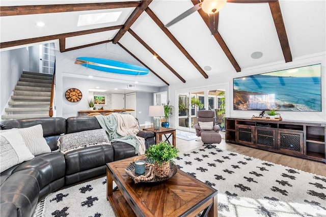 living room featuring stairway, beam ceiling, high vaulted ceiling, and wood finished floors