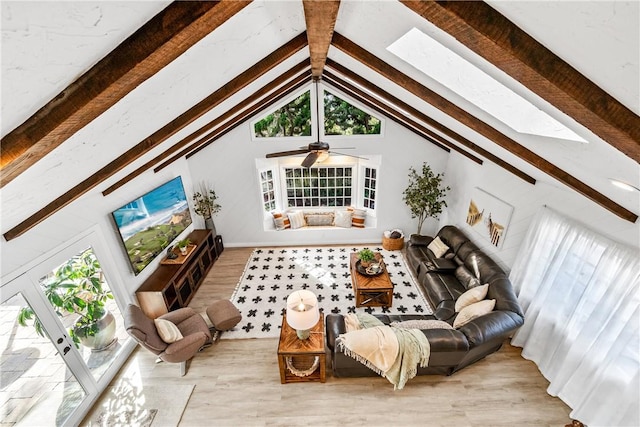 living room with vaulted ceiling with skylight and wood finished floors