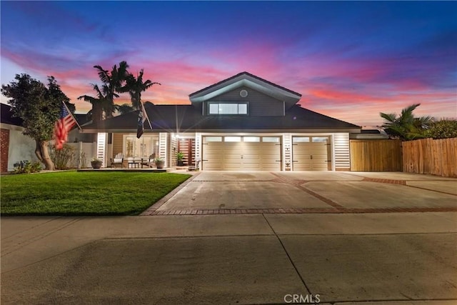 view of front of property featuring a front yard, fence, and driveway