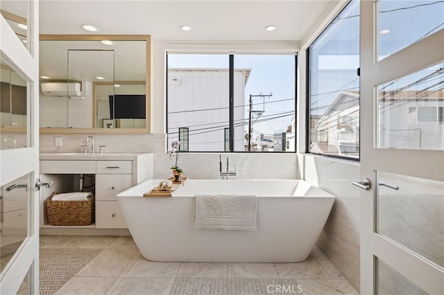 bathroom featuring vanity, a bathing tub, and a wall unit AC