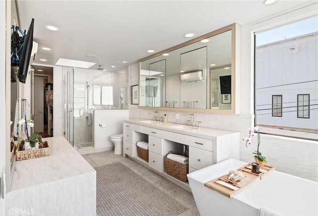 full bathroom featuring vanity, a wealth of natural light, toilet, and separate shower and tub