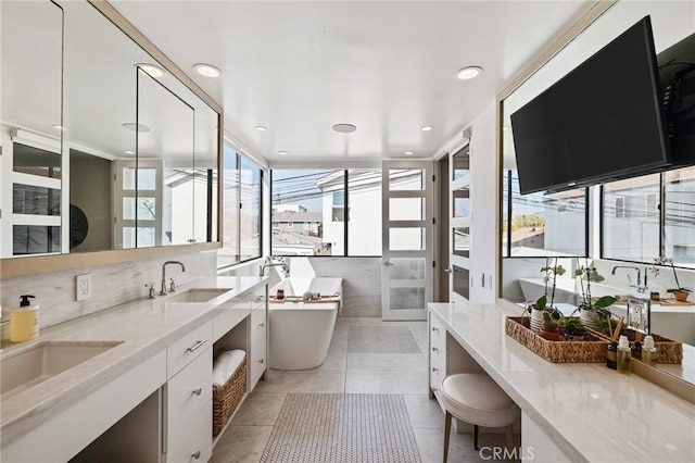 bathroom featuring a washtub, vanity, backsplash, and tile patterned floors