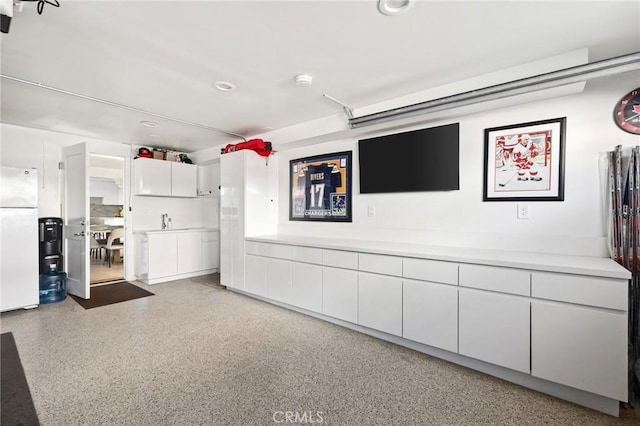 interior space featuring white fridge and white cabinets