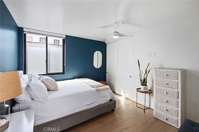 bedroom with hardwood / wood-style floors, a closet, and ceiling fan