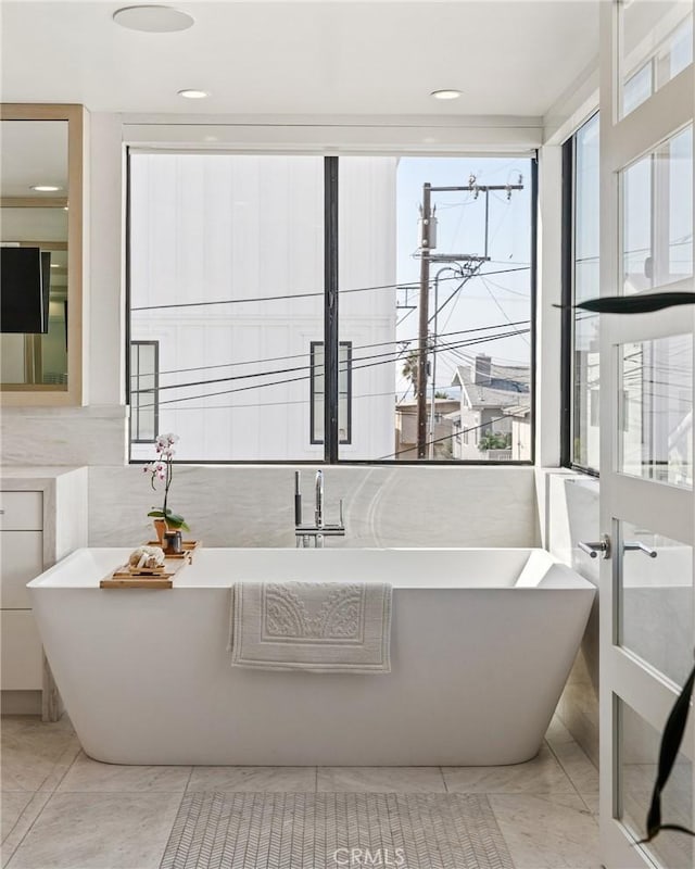 bathroom featuring tile walls and a tub to relax in