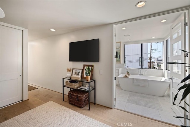 bathroom with a bath and hardwood / wood-style floors