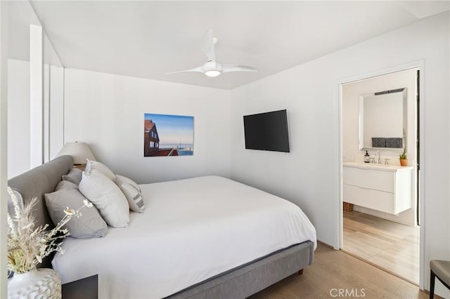 bedroom with sink, light hardwood / wood-style flooring, ceiling fan, and ensuite bathroom