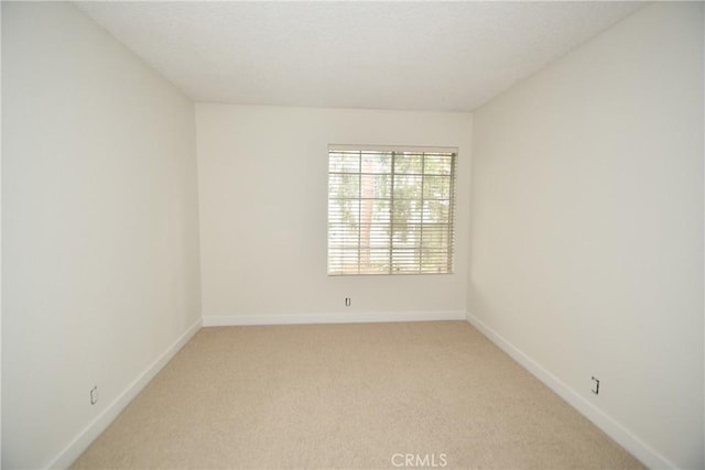 unfurnished room featuring light carpet