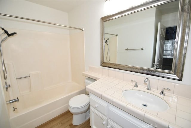 full bathroom with vanity, hardwood / wood-style flooring, shower / tub combination, and toilet