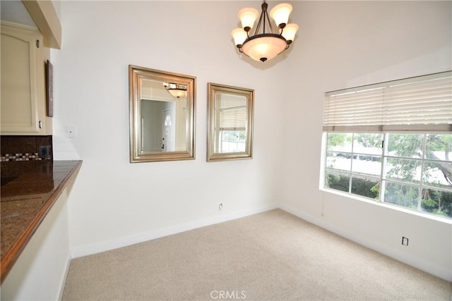 interior space featuring light colored carpet and a notable chandelier