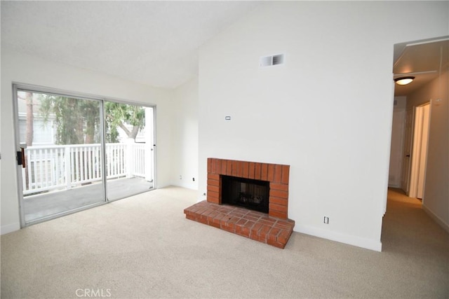 carpeted living room with a fireplace and high vaulted ceiling