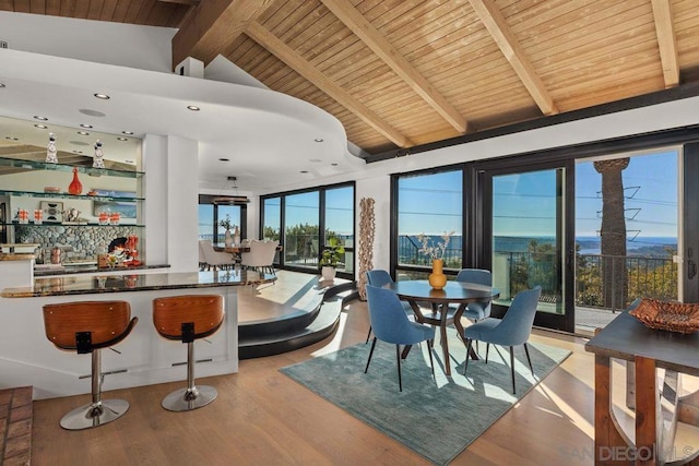 dining area with beamed ceiling, high vaulted ceiling, wooden ceiling, and light wood-type flooring