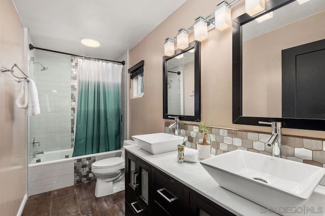 full bathroom with tasteful backsplash, vanity, toilet, and shower / bath combo with shower curtain